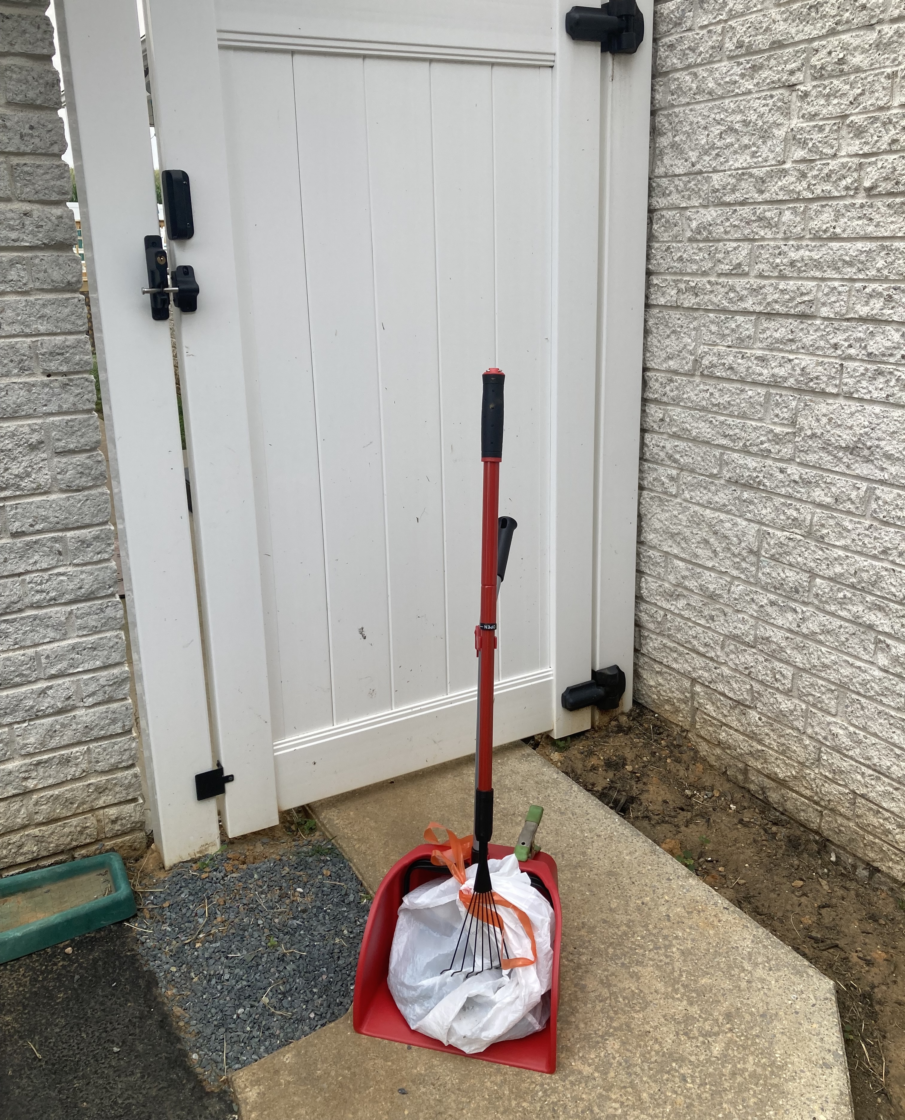 Poop scooping near fenced yard gate